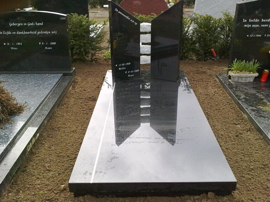 Zwarte grafsteen met staande elementen